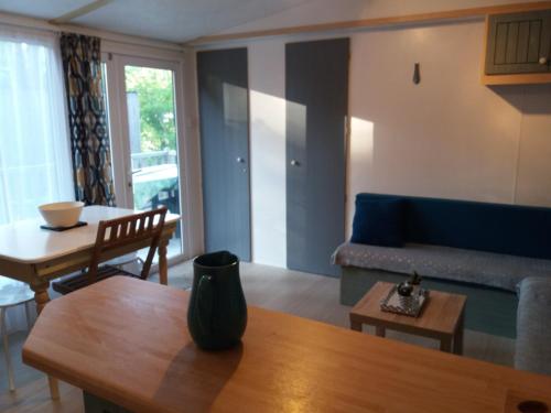 un salon avec un canapé bleu et une table dans l'établissement Roc Han mobil, à Rohan