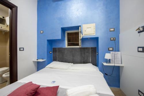 Cama en habitación con pared azul en B&B Napolì 2, en Nápoles