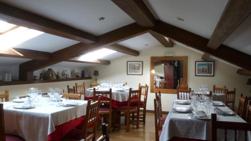 a dining room with tables and chairs with white tablecloths at Hotel Las Murallas in Avila