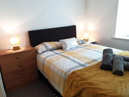 a bedroom with a bed and a dresser with two lamps at 2 Bedroom Apartment Warrington Free Parking Hosted By Seren Property in Warrington