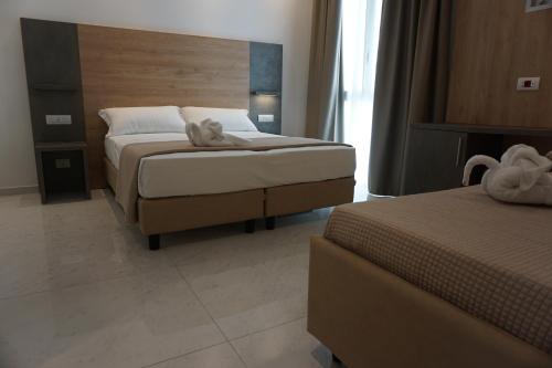 a bedroom with two beds with a stuffed animal on the bed at Hotel Ducale in Rimini
