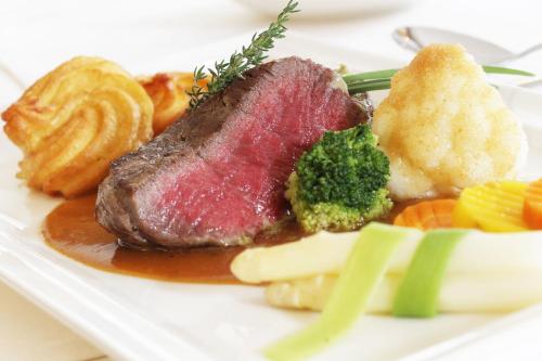 a plate of food with meat broccoli and other foods at Hotel Finkenbergerhof in Finkenberg