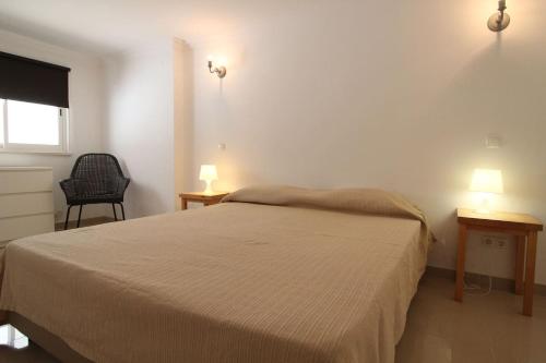 a bedroom with a bed and two tables and two lamps at Lotus Villa V5 com piscina comum - Boliqueime, Algarve in Boliqueime