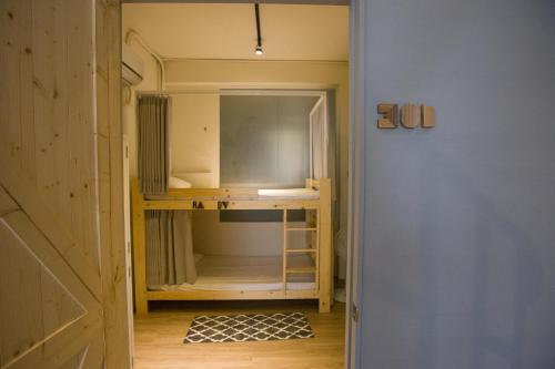 a room with a bunk bed and a mirror at KM Hostel in Chiayi City