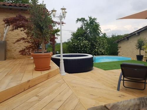una terraza de madera con una hoguera en el patio trasero en Le Clos des Bories Le Gîte, en Sarlat-la-Canéda