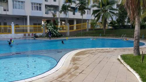 a large swimming pool with people in the water at PD Homestay Laguna / Ocean Apartment in Port Dickson