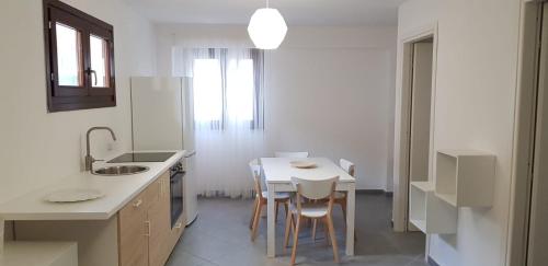 a white kitchen with a white table and chairs at Boa Vista Favignana - Nuova Gestione 2026 in Favignana