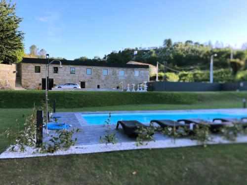 a large swimming pool in a yard with a building at Quinta das Lavandeiras - Caldas de Vizela in Vizela