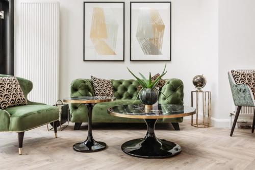 a living room with a green couch and a table at C-Hotels Continental in De Panne