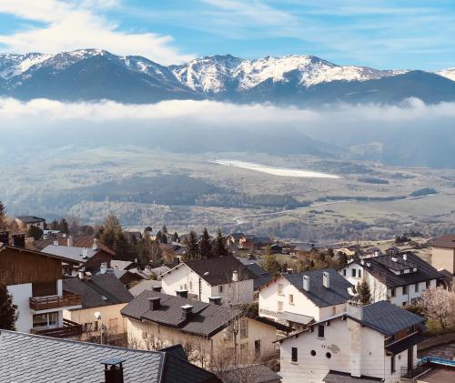 a village with snow covered mountains in the background at Résidence Le Pic de l'Ours in Font-Romeu