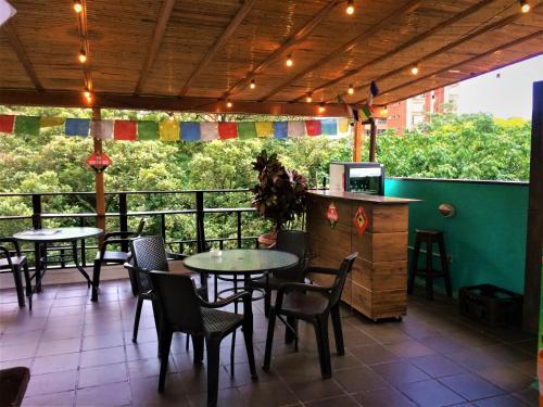 Casa Kiwi Hostel في ميديلين: مطعم على طاولات وكراسي على شرفة