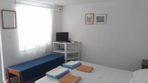 Zimmer mit 2 Betten und einem Schreibtisch mit Fenster in der Unterkunft Apartments Lončarević in Slano