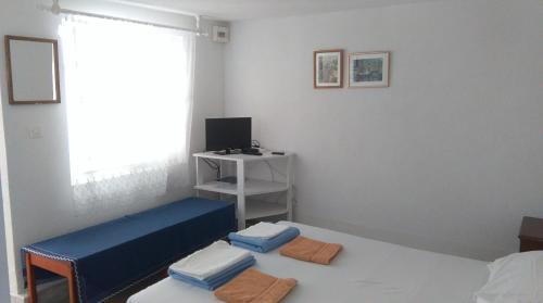 a room with two beds and a desk with a window at Apartments Lončarević in Slano