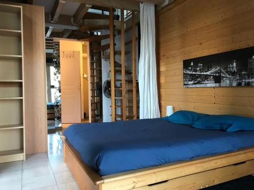 - une chambre avec un lit bleu dans un mur en bois dans l'établissement Pilier de la Fontaine - avec parking, à Metz