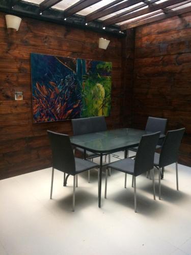 a table and chairs in a room with a painting at Casa Kiwi Hostel in Medellín