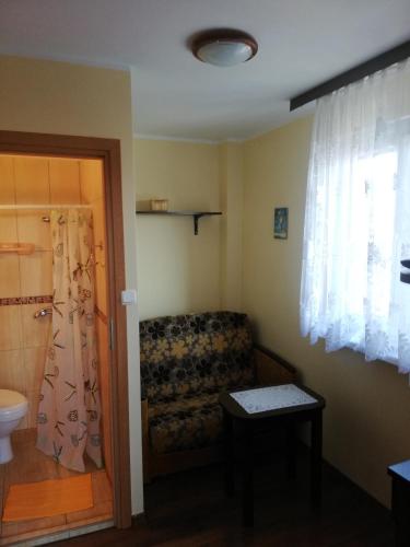 a living room with a couch and a window at Pokoje Gościnne Słoneczko in Kąty Rybackie