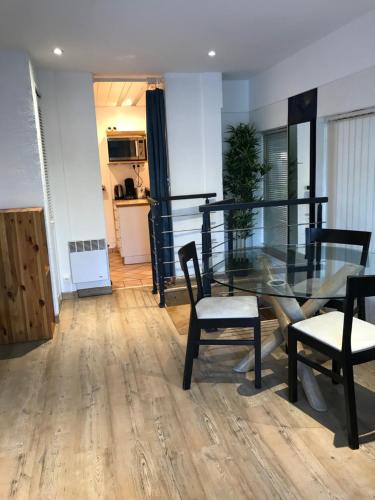 une salle à manger avec une table et des chaises en verre dans l'établissement Pilier de la Fontaine - avec parking, à Metz