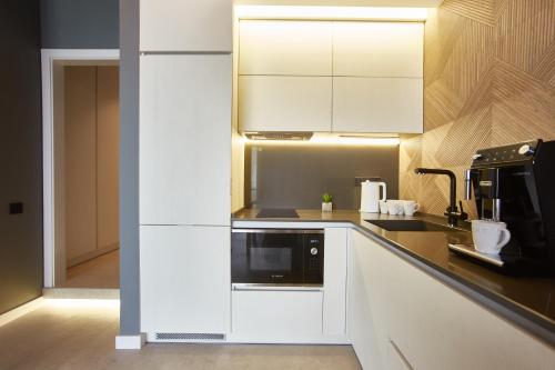 a kitchen with white cabinets and a microwave at Gagarin Plaza Luxury Sea View Apartments in Odesa