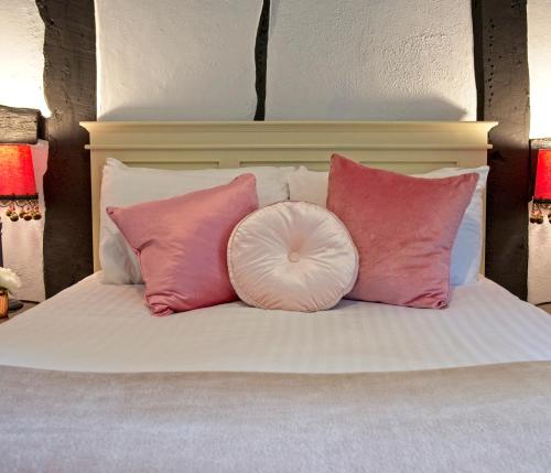 a bed with pink and white pillows on it at The Old Vicarage Hotel & Restaurant in Bridgwater