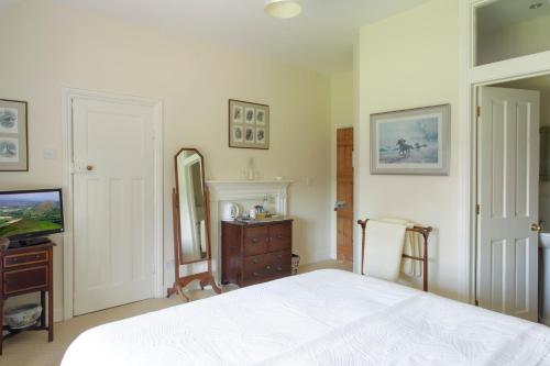 a bedroom with a white bed and a television at Church Farm B&B near Telford and Ironbridge in Shifnal