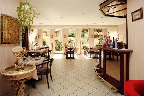 ein Restaurant mit Tischen und Stühlen in einem Zimmer in der Unterkunft Astoria Hotel in Trier