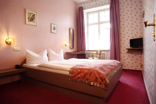 
a bedroom with a white bedspread and pillows at Astoria Hotel in Trier
