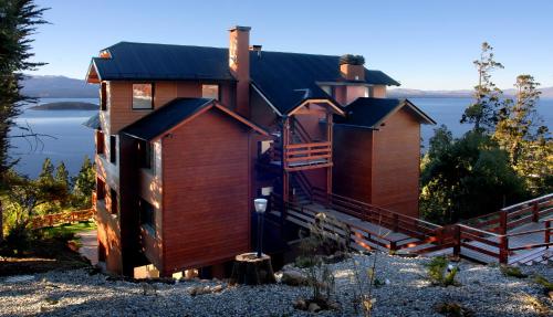 a house on the shore of a body of water at Catalonia Sur Aparts-Spa in San Carlos de Bariloche