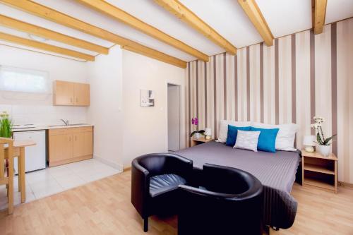 1 dormitorio con 1 cama con silla y cocina en Apartman Szanyi, en Bük
