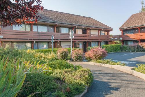 un edificio con una carretera delante de él en Hôtel Restaurant Campanile Aurillac, en Aurillac