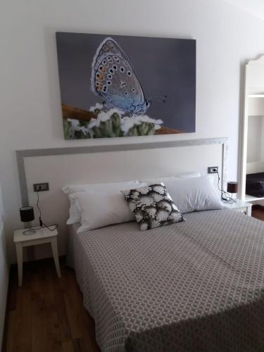a bedroom with a bed with a butterfly on the wall at LOCANDA RIGHETTO in Quinto di Treviso