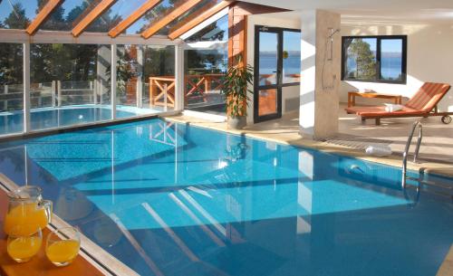 a large swimming pool with blue water in a house at Catalonia Sur Aparts-Spa in San Carlos de Bariloche