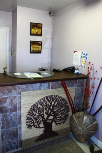 a bathroom with a tree painted on the wall at Hawberry Motel in Little Current