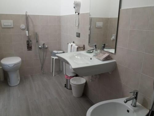 a bathroom with a sink and a toilet and a mirror at LOCANDA RIGHETTO in Quinto di Treviso