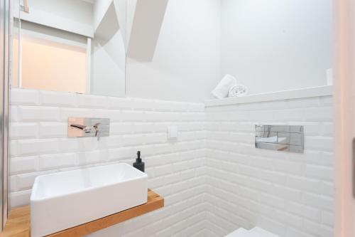 ein weißes Badezimmer mit Waschbecken und Spiegel in der Unterkunft Your Lisbon Home Bairro Alto in Lissabon