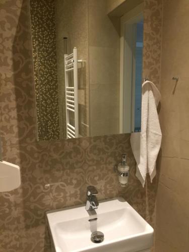 uma casa de banho com um lavatório e um espelho em ARENA PULA CENTAR APARTMENT em Pula