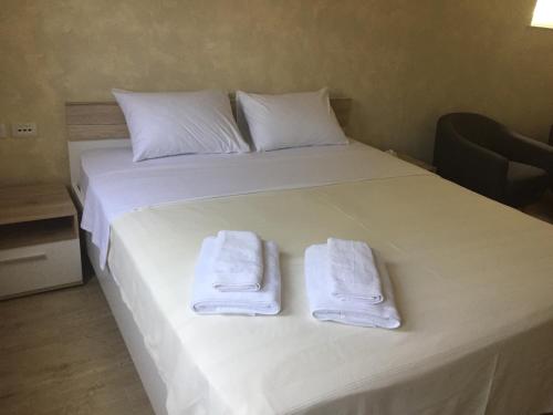 a white bed with two towels on top of it at ARENA PULA CENTAR APARTMENT in Pula