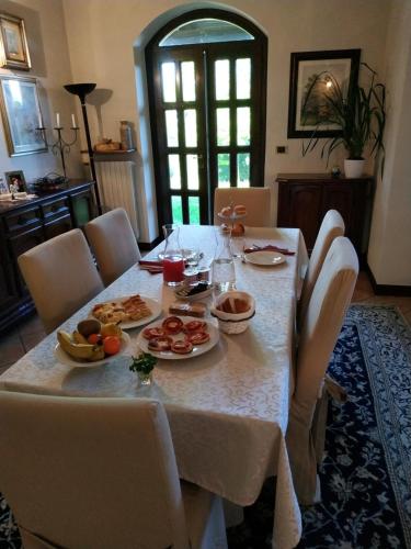 a table with a white table cloth and food on it at Suite Villa Aurelj in Barolo