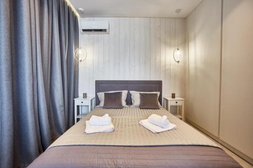 a bedroom with a bed with two towels on it at Gagarin Plaza Luxury Sea View Apartments in Odesa