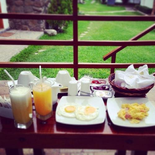 a table with breakfast food and two glasses of orange juice at El Molino Hotel y Restaurant in Lunahuaná