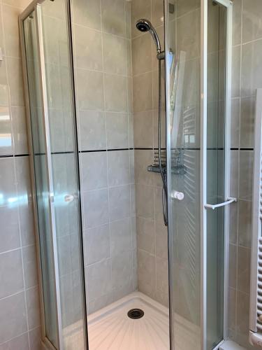 La salle de bains est pourvue d'une douche en verre. dans l'établissement Charmante maison en pierre au coeur du Berry, à Parnac