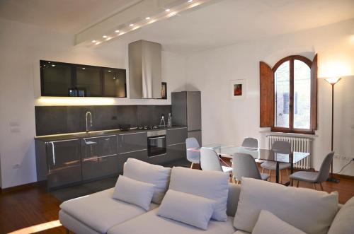 un soggiorno con divano bianco e tavolo di S.M. VICOLO DELL'ORO a San Gimignano