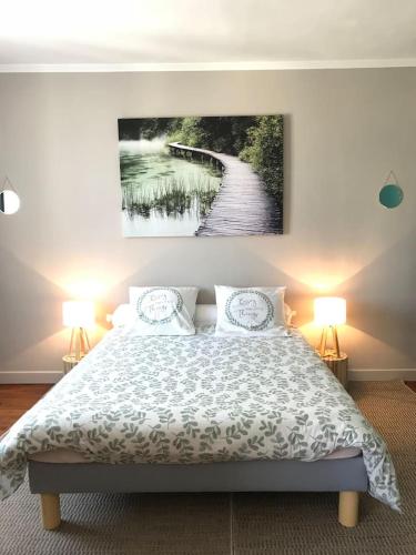 une chambre avec un lit avec un tableau sur le mur dans l'établissement appartement de charme en plein coeur du centre ville de Compiègne, à Compiègne