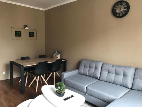 uma sala de estar com um sofá e uma mesa em appartement de charme en plein coeur du centre ville de Compiègne arriver entre 14h et 18h maximum em Compiègne