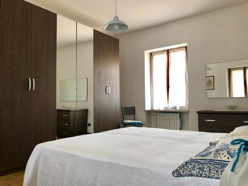 una camera da letto con un grande letto bianco e uno specchio di Casa Olinda a Lazise