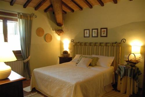 Schlafzimmer mit einem Bett mit weißer Bettwäsche und einem Fenster in der Unterkunft La Pintura in Trevi