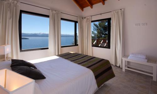 um quarto com uma cama e 2 janelas grandes em Catalonia Sur Aparts-Spa em San Carlos de Bariloche