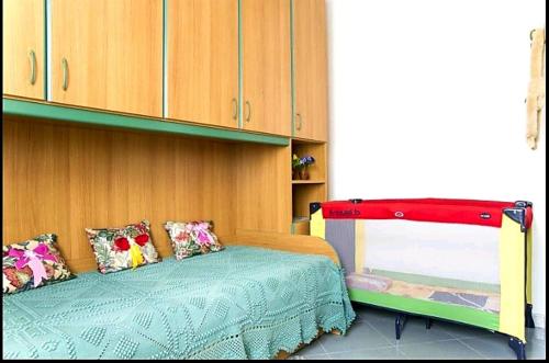 a bedroom with a bed and a cabinet at Appartamento Vacanza Barisardo SB in Bari Sardo