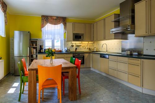 a kitchen with a wooden table and colorful chairs at Ferienwohnungen Ender in Sebnitz