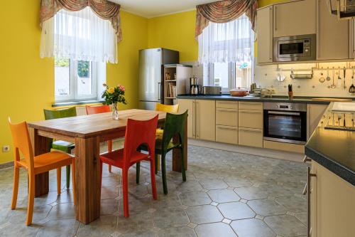 a kitchen with a wooden table and chairs at Ferienwohnungen Ender in Sebnitz
