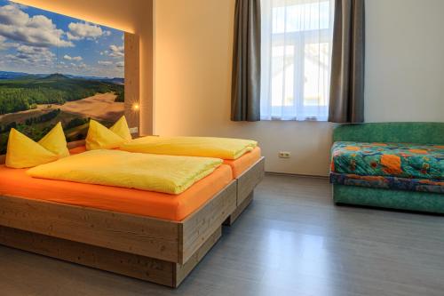a bedroom with two beds and a chair at Ferienwohnungen Ender in Sebnitz